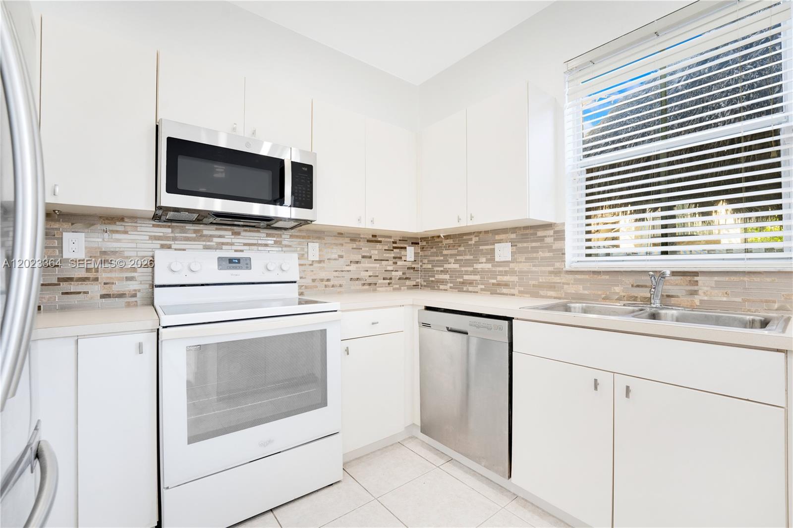 27433 Southwest 137th Court, Unit 1 Homestead, FL 33032 - Photo 10 of 28 a kitchen with granite countertop cabinets stainless steel appliances and a sink
