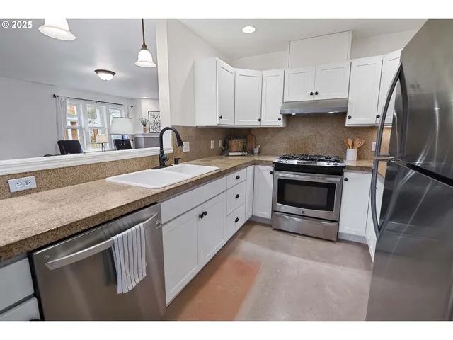 a kitchen with granite countertop a stove sink and refrigerator