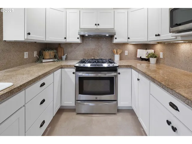 a kitchen with granite countertop a stove sink and cabinets
