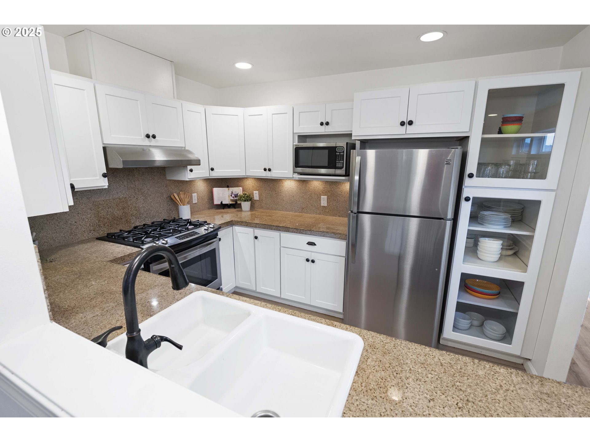 265 23rd Street Astoria, OR 97103 - Photo 13 of 36 a kitchen with a refrigerator a stove and white cabinets