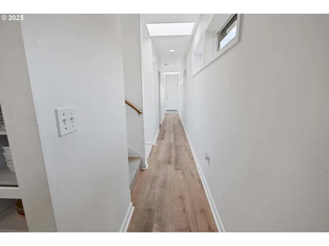 a view of a hallway with wooden floor and staircase