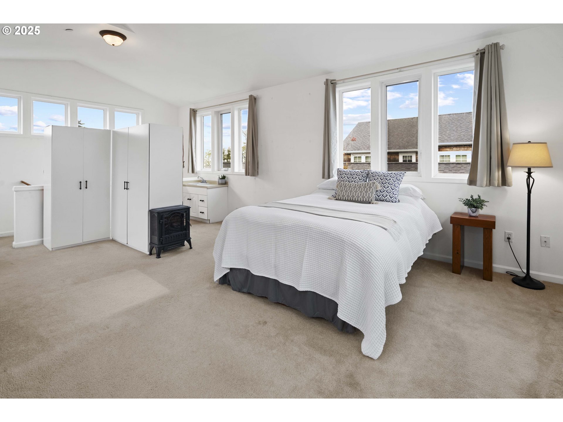 265 23rd Street Astoria, OR 97103 - Photo 16 of 36 a spacious bedroom with a bed and lamp