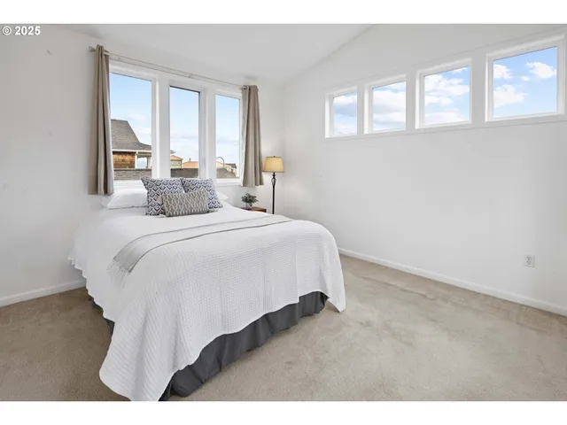 a bedroom with a bed and windows