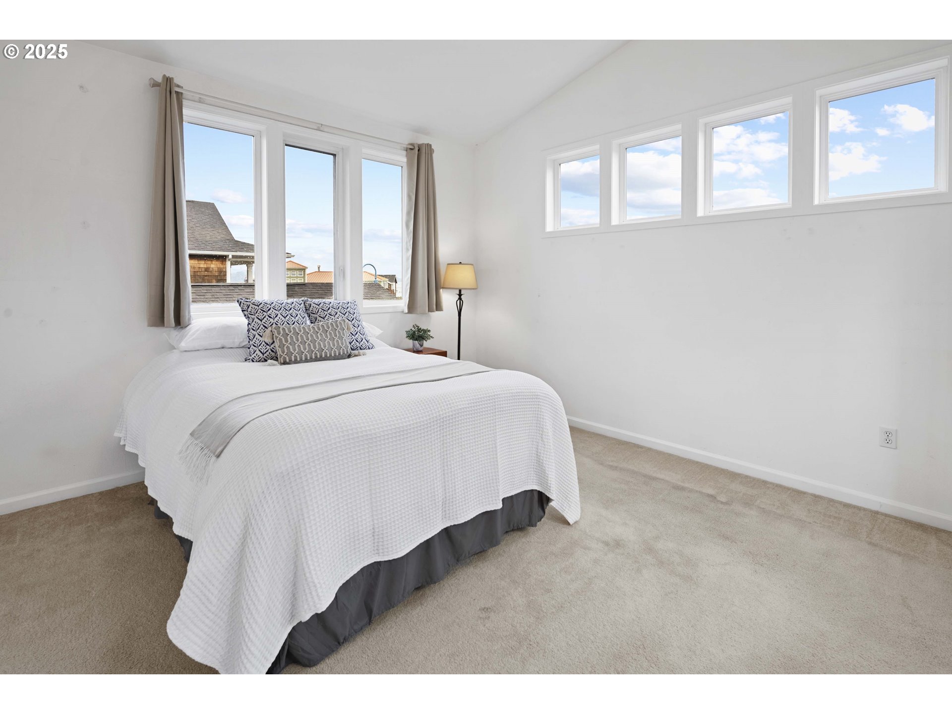 265 23rd Street Astoria, OR 97103 - Photo 18 of 36 a bedroom with a bed and windows