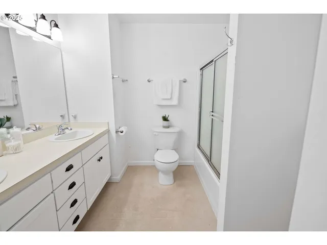 a bathroom with a double vanity sink toilet and shower