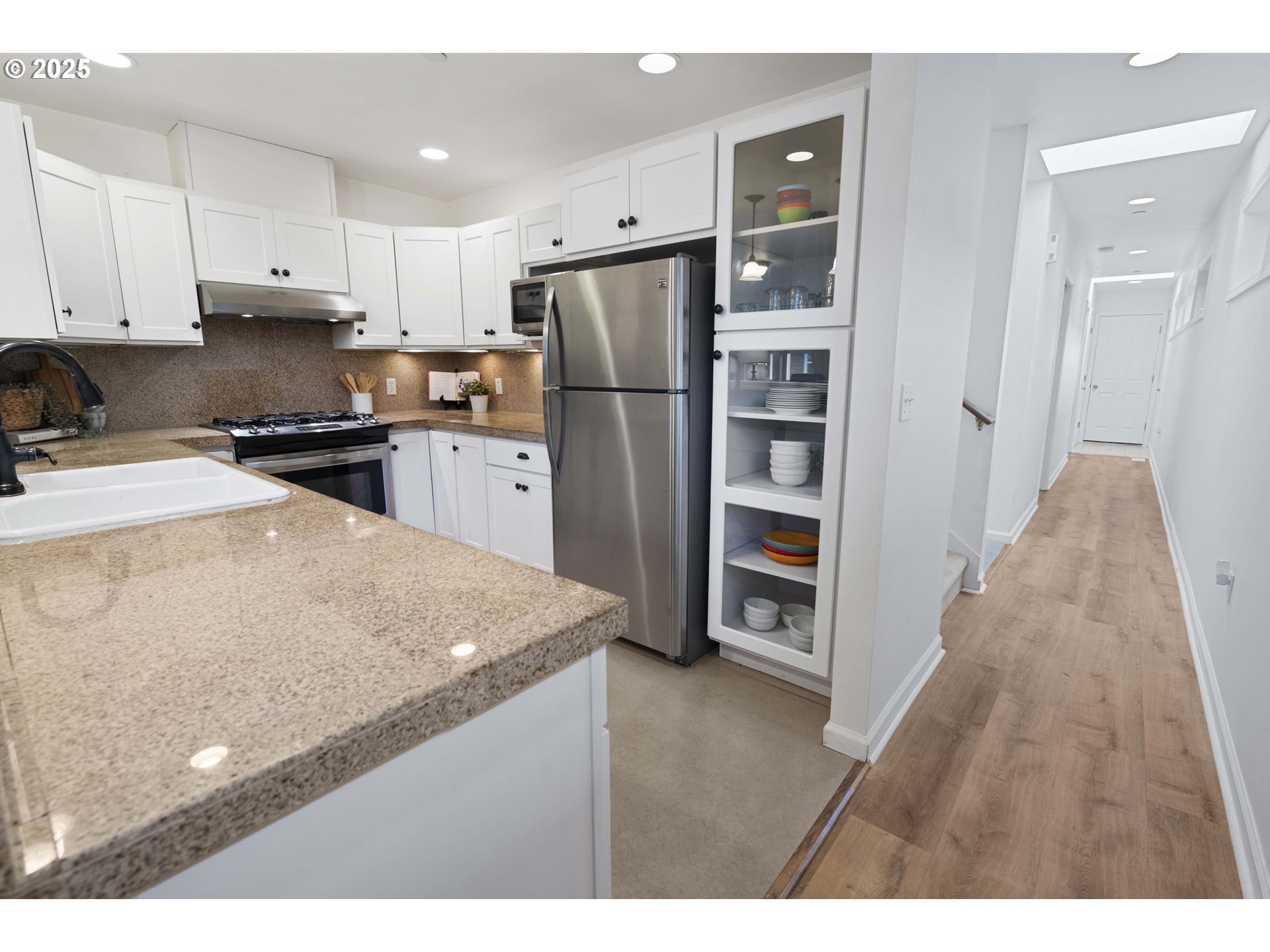 265 23rd Street Astoria, OR 97103 - Photo 9 of 36 a kitchen with a refrigerator a stove top oven and wooden floor