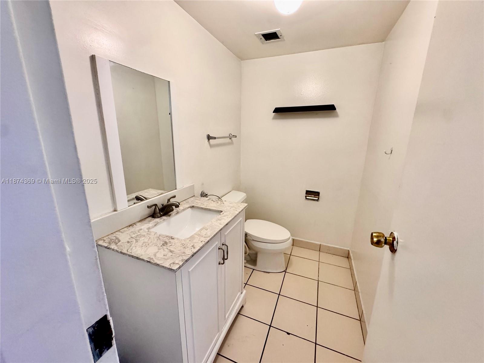 13499 Biscayne Boulevard, Unit 703 North Miami, FL 33181 - Photo 12 of 22 a bathroom with a sink toilet and mirror