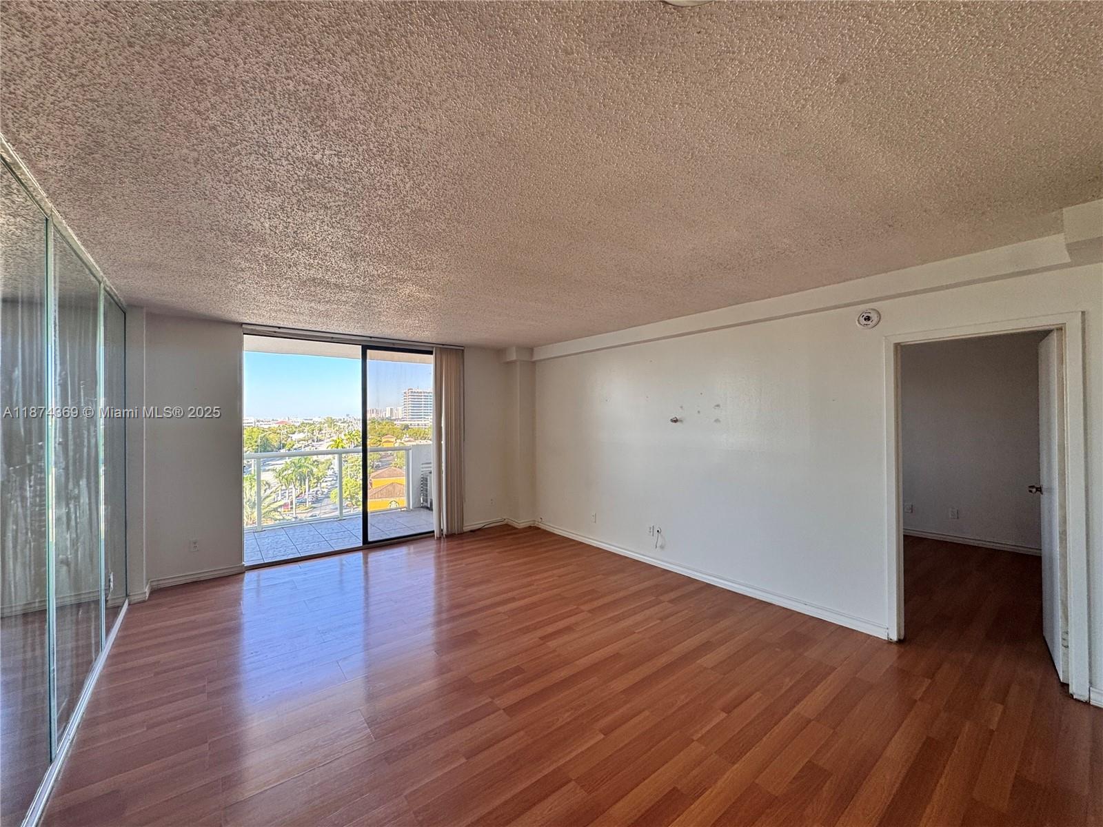 13499 Biscayne Boulevard, Unit 703 North Miami, FL 33181 - Photo 21 of 22 an empty room with wooden floor and windows