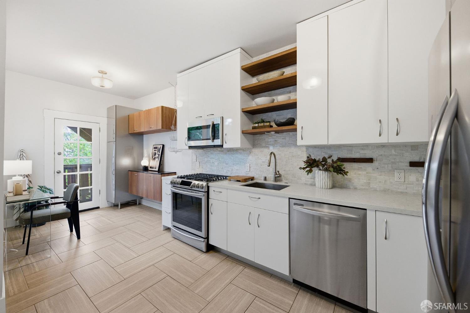 3452 18th Street, Unit A San Francisco, CA 94110 - Photo 12 of 39 a kitchen with stainless steel appliances granite countertop a stove a sink and a refrigerator