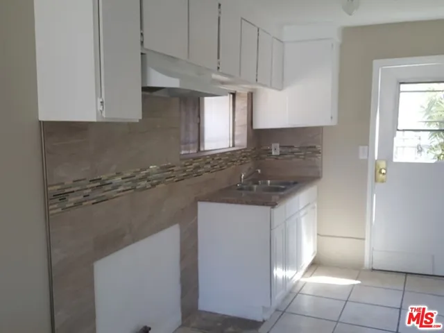 a kitchen with granite countertop a sink a stove and cabinets