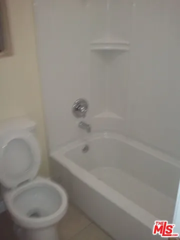 a white bath tub sitting next to a toilet