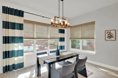 a kitchen with stainless steel appliances kitchen island granite countertop a table chairs in it and wooden floors