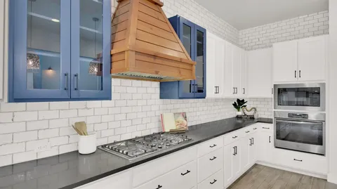 a kitchen with a sink dishwasher a stove and a refrigerator with wooden floor