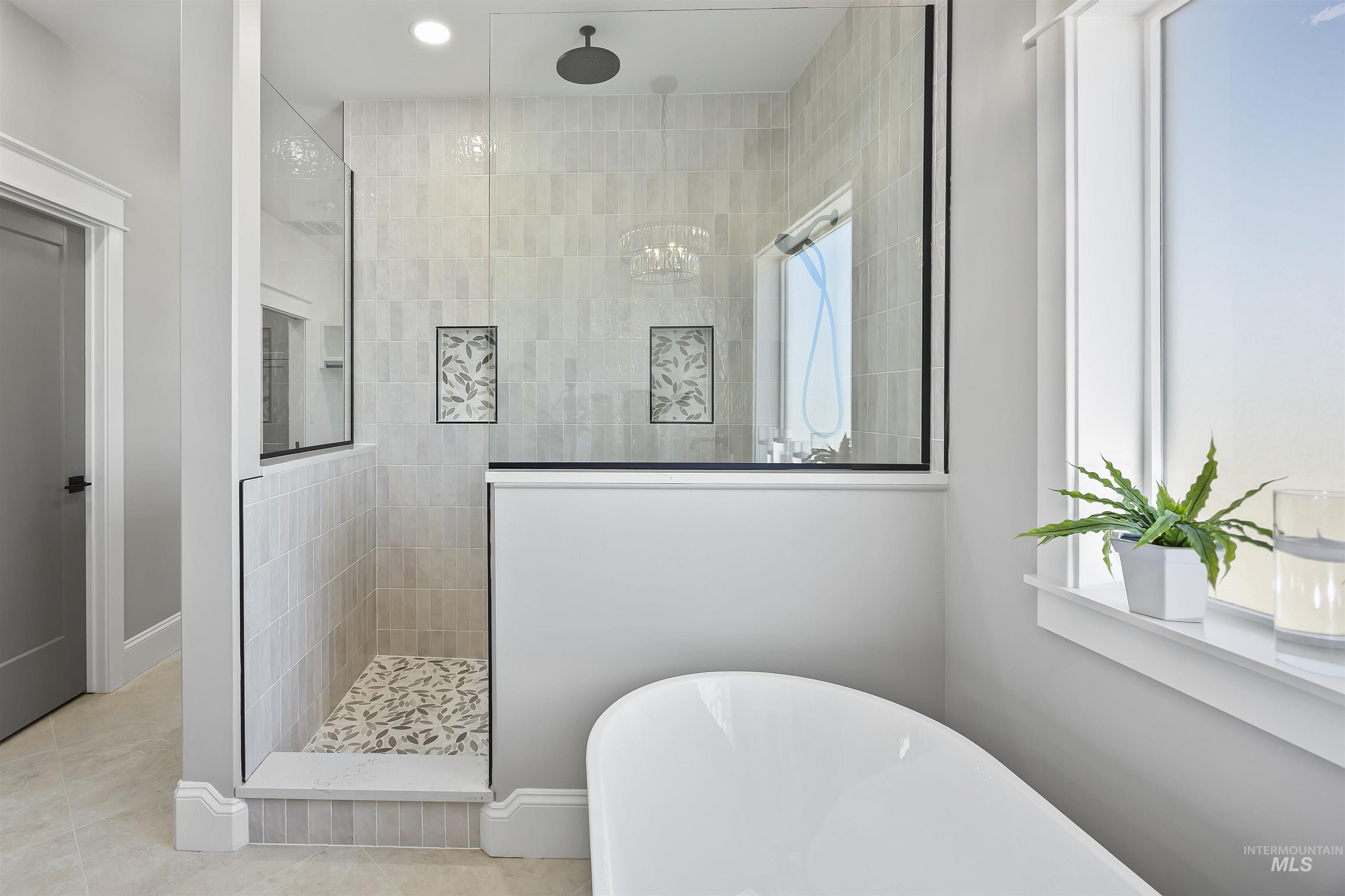 378 West 100 South Rupert, ID 83350 - Photo 27 of 50 Modern bathroom featuring a freestanding soaking tub, a frameless glass shower enclosure with a rainfall showerhead, tiled shower walls, a patterned shower floor, and a large window with white trim