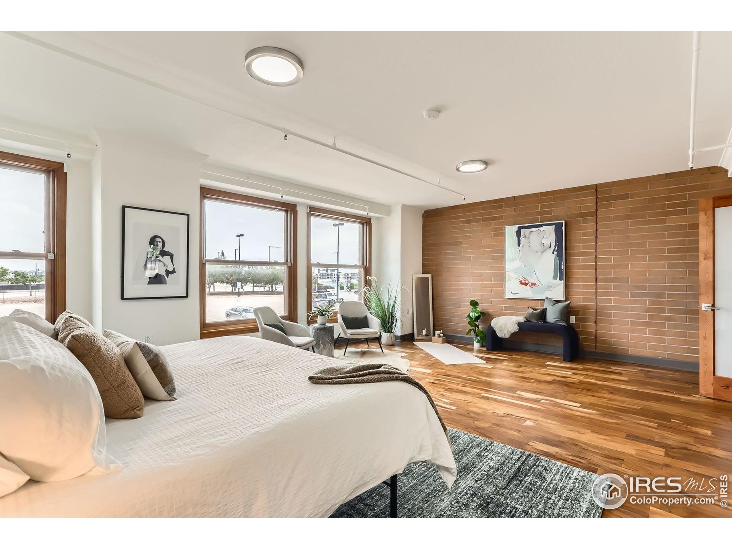 2245 Blake Street, Unit D Denver, CO 80205 - Photo 16 of 36 a large bedroom with a bed a large window and couch