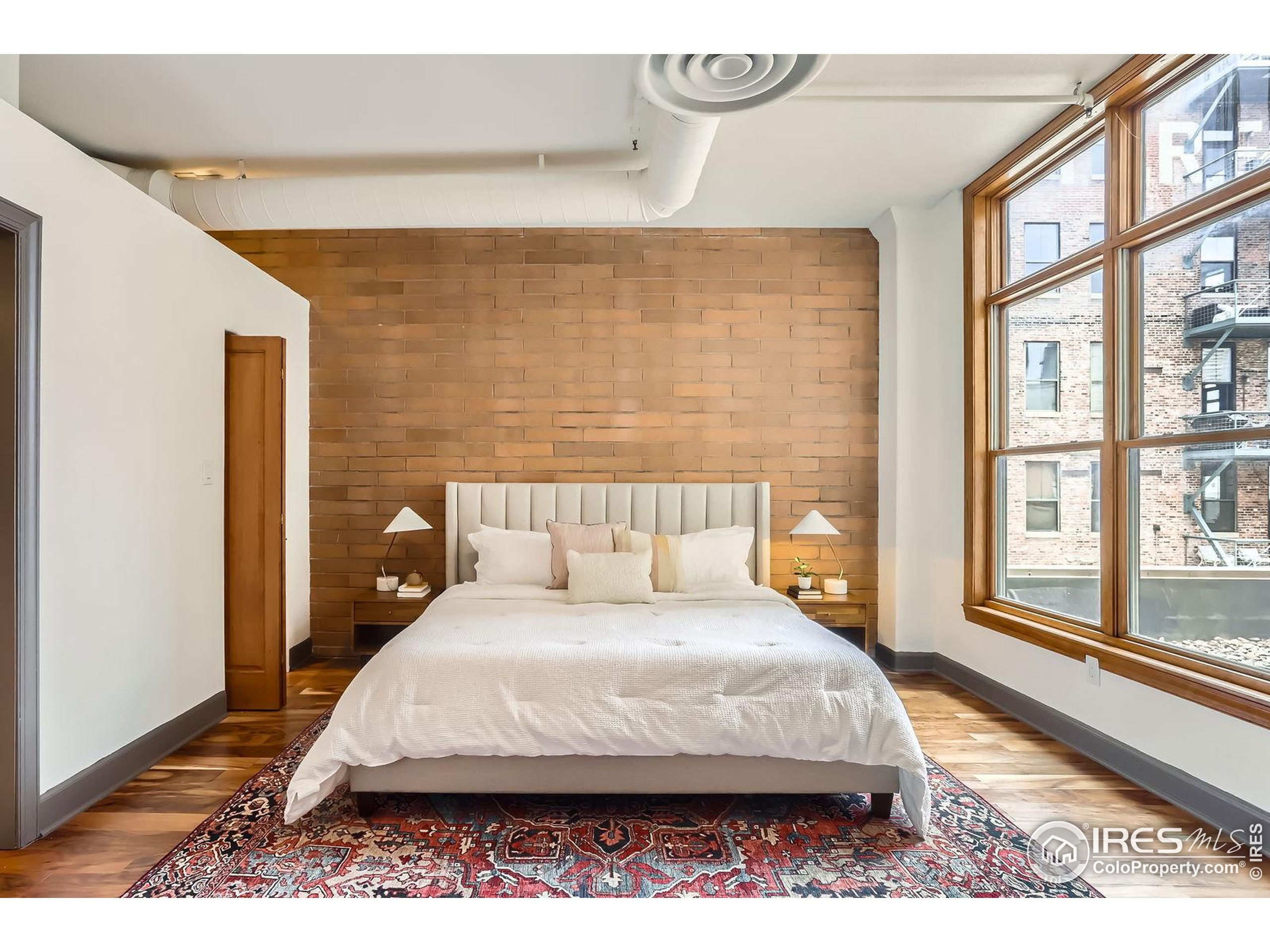 2245 Blake Street, Unit D Denver, CO 80205 - Photo 7 of 36 a large bed sitting in a bedroom next to a window