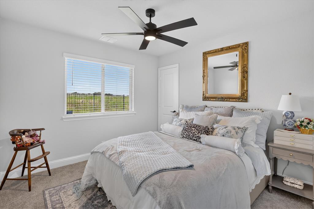 833 Godley Ranch Godley, TX 76044 - Photo 17 of 31 Spacious room featuring a large window, a ceiling fan with integrated lighting, neutral-toned walls, and carpet flooring