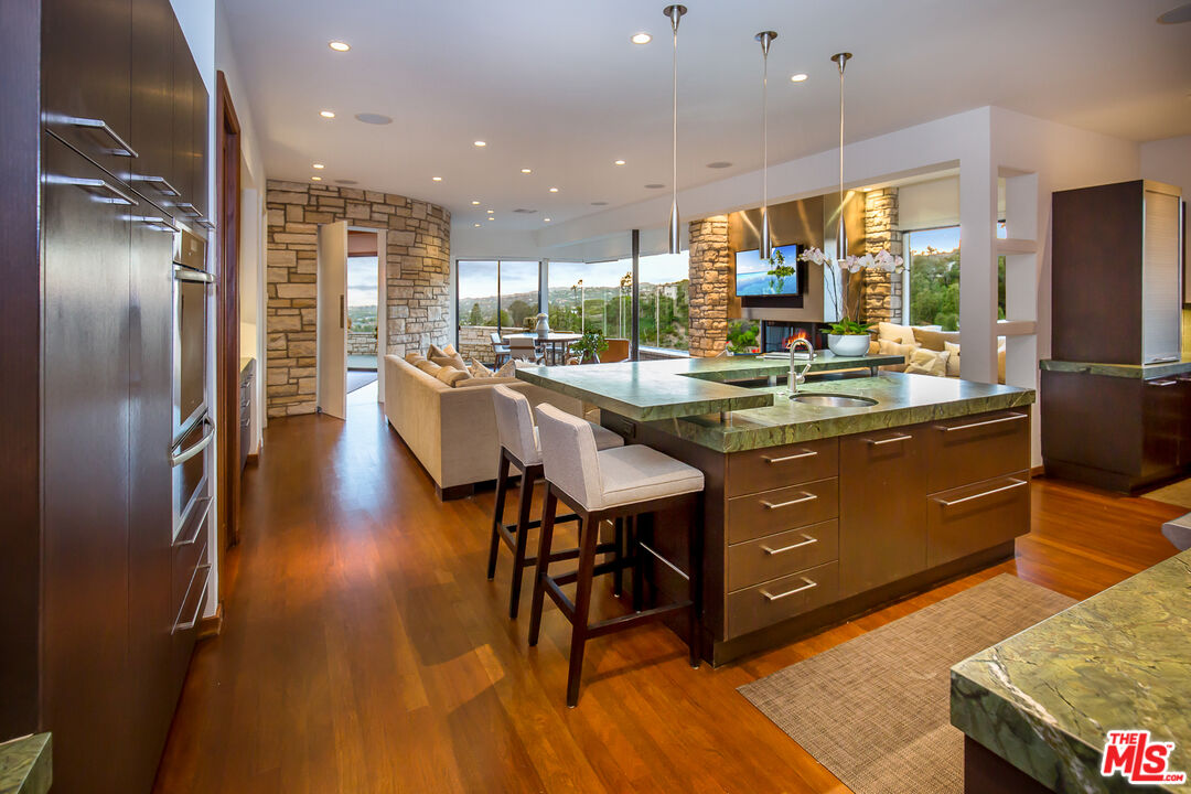 1131 Miradero Road Beverly Hills, CA 90210 - Photo 13 of 42 a kitchen with stainless steel appliances granite countertop a sink a stove and a refrigerator