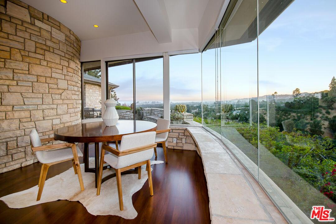 1131 Miradero Road Beverly Hills, CA 90210 - Photo 14 of 42 a view of a porch with furniture and wooden floor