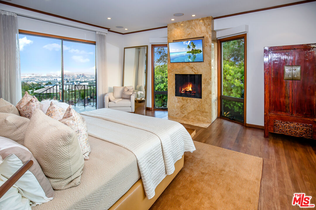 1131 Miradero Road Beverly Hills, CA 90210 - Photo 16 of 42 a spacious bedroom with a bed and a large window