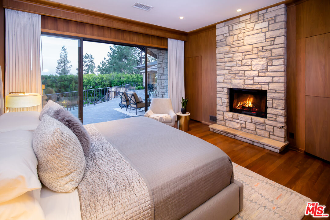 1131 Miradero Road Beverly Hills, CA 90210 - Photo 22 of 42 a bed room with a bed and a fireplace