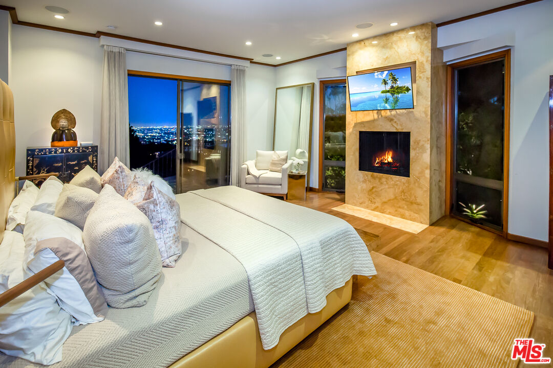 1131 Miradero Road Beverly Hills, CA 90210 - Photo 29 of 42 a bedroom with a bed and a fireplace