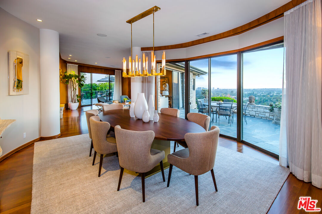 1131 Miradero Road Beverly Hills, CA 90210 - Photo 7 of 42 a dining room with furniture a chandelier and wooden floor