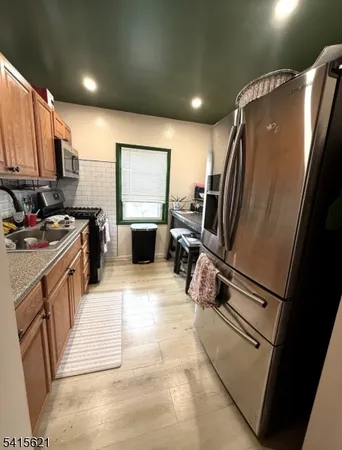 a kitchen with stainless steel appliances a refrigerator sink and stove
