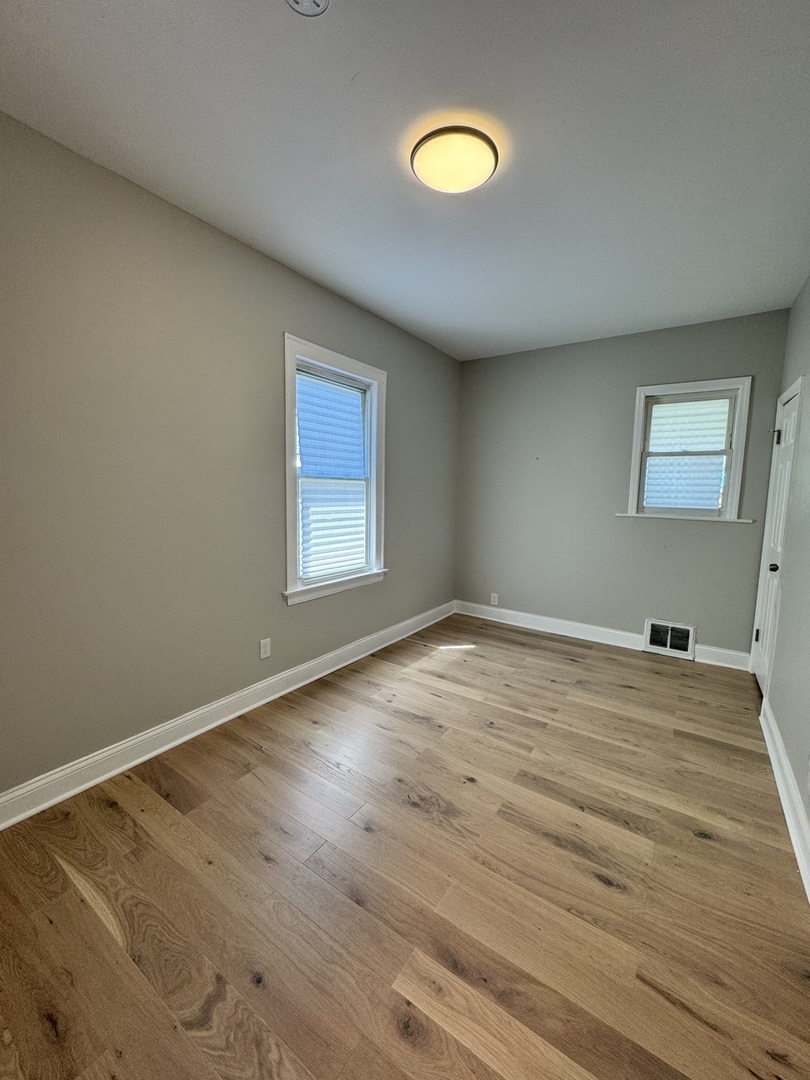 822 East 87th Place Chicago, IL 60619 - Photo 12 of 31 a view of a room with wooden floor and fan