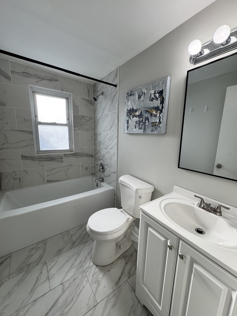 822 East 87th Place Chicago, IL 60619 - Photo 17 of 31 a bathroom with a sink toilet a mirror and shower