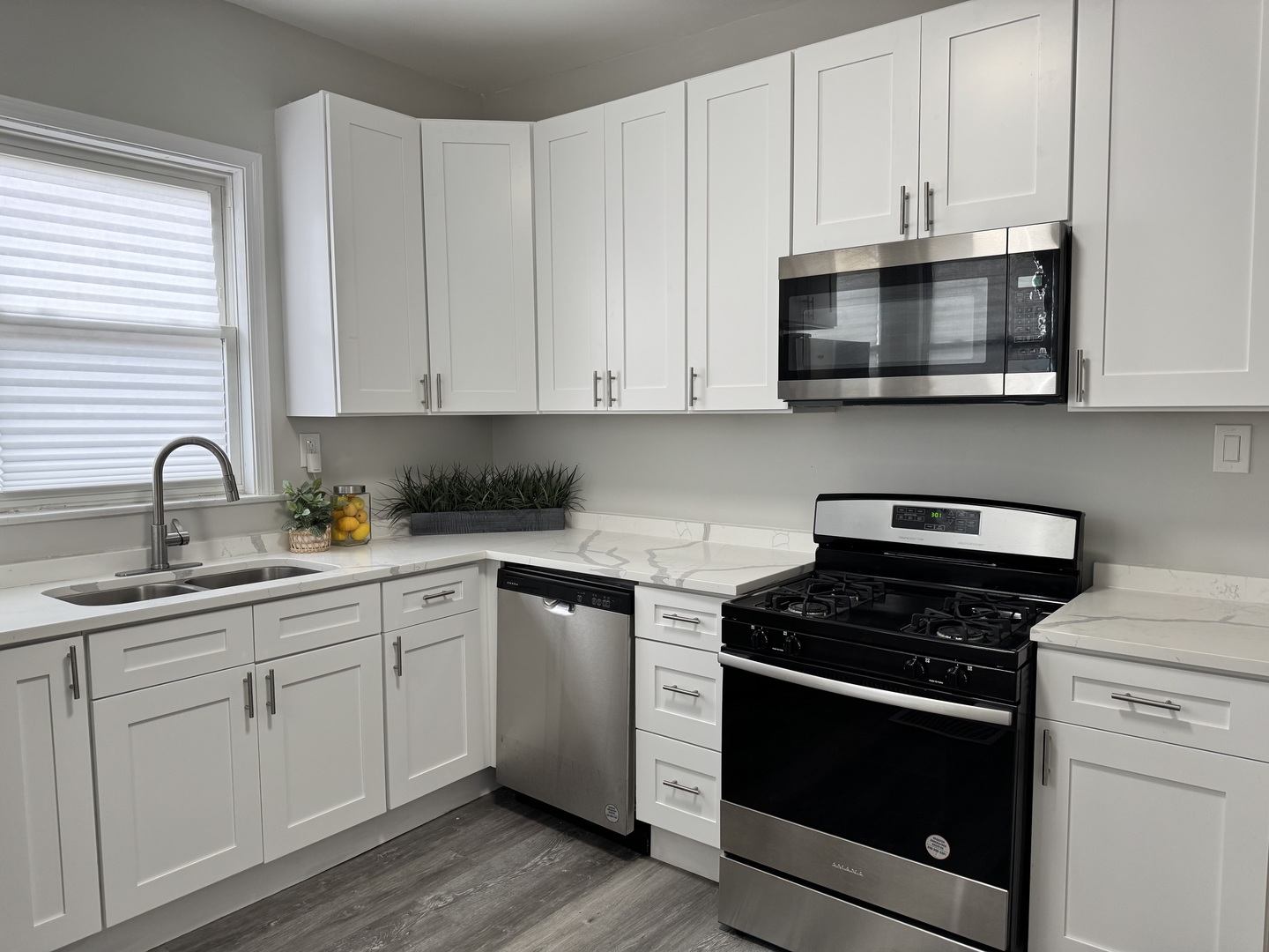 822 East 87th Place Chicago, IL 60619 - Photo 9 of 31 a kitchen with white cabinets and stainless steel appliances
