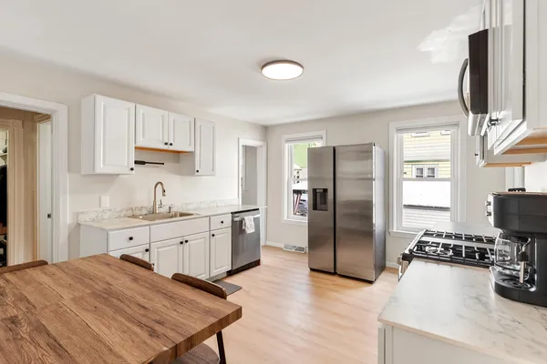 a kitchen with granite countertop a refrigerator stove top oven and sink