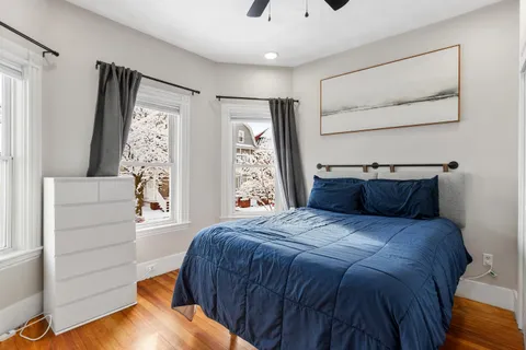 a bedroom with a bed and wooden floor