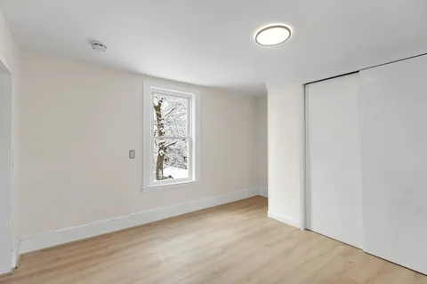 an empty room with windows and closet