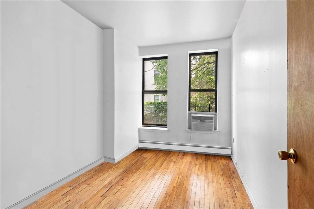 1012 Faile Street, Unit 1012A Bronx, NY 10459 - Photo 16 of 20 an empty room with wooden floor and windows