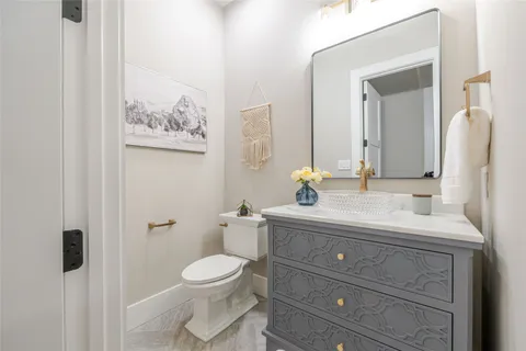 a bathroom with a granite countertop toilet sink and mirror