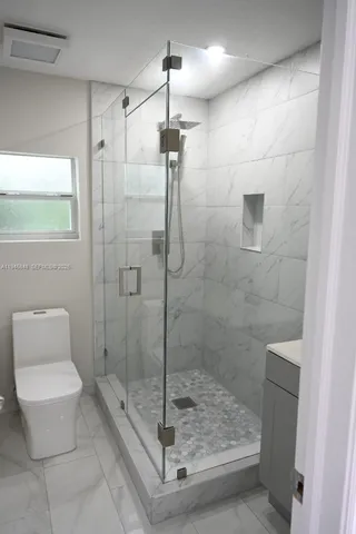 a bathroom with a shower a toilet and sink