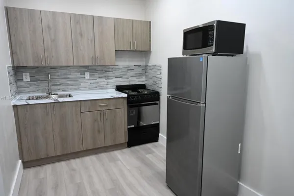 a kitchen with a refrigerator sink and cabinets