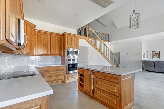 a kitchen with stainless steel appliances granite countertop a sink and dishwasher a refrigerator with wooden floor