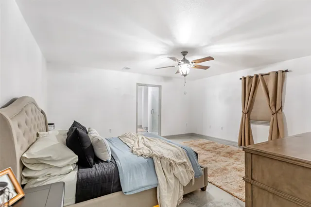 a bedroom with a bed and ceiling fan