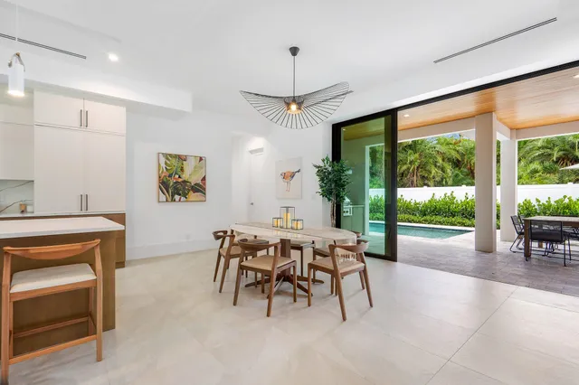 a dining room with furniture and a floor to ceiling window