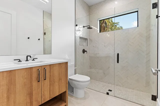 a bathroom with a sink a toilet and shower