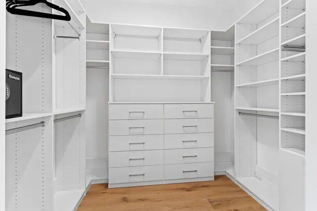 a view of walk in closet with empty racks