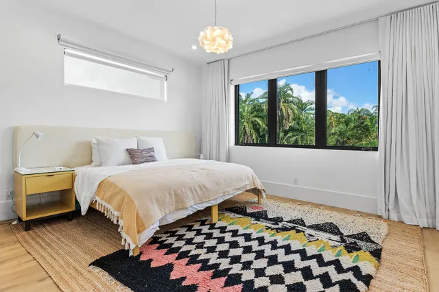 a bedroom with a bed and a lamp next to a window