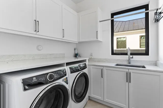 a utility room with sink dryer and washer