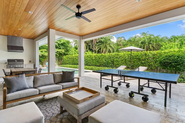 a living room with patio furniture and a floor to ceiling window