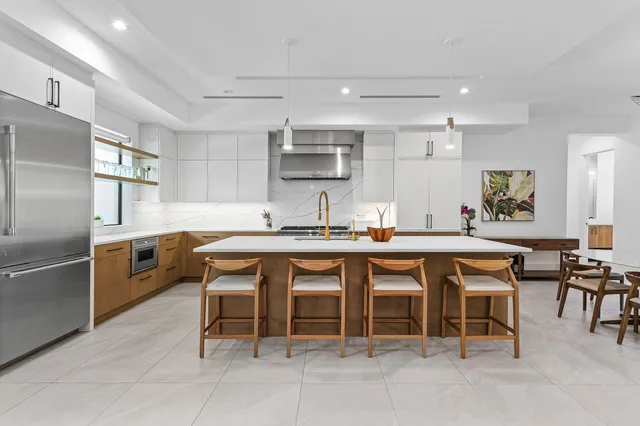 a kitchen with stainless steel appliances granite countertop table chairs sink and cabinets