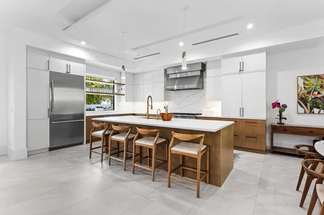 a kitchen with stainless steel appliances kitchen island granite countertop a table chairs sink and microwave