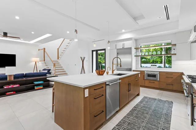 a kitchen with a stove a sink a counter top space and living room