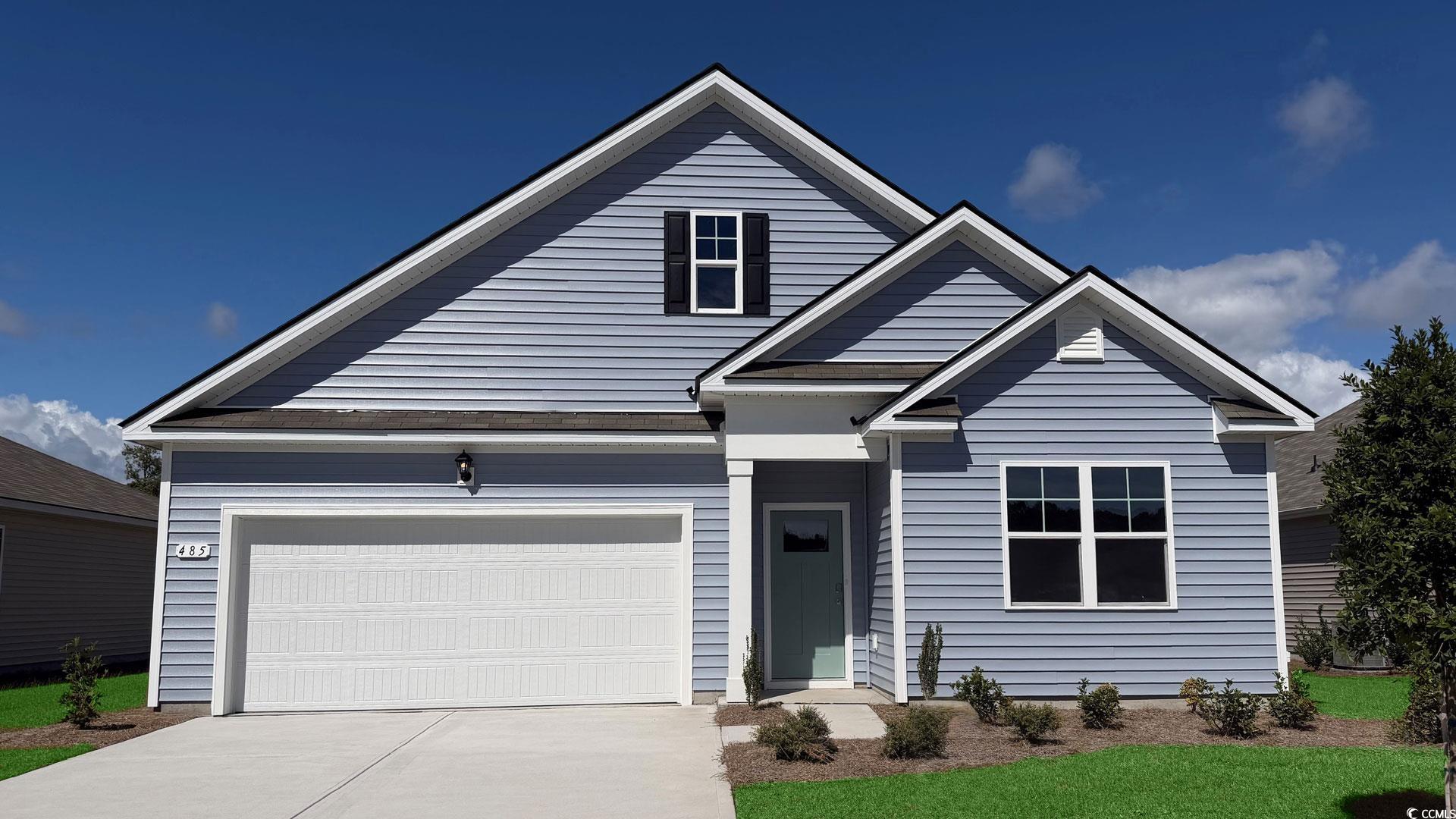 Traditional home featuring a garage and concrete driveway